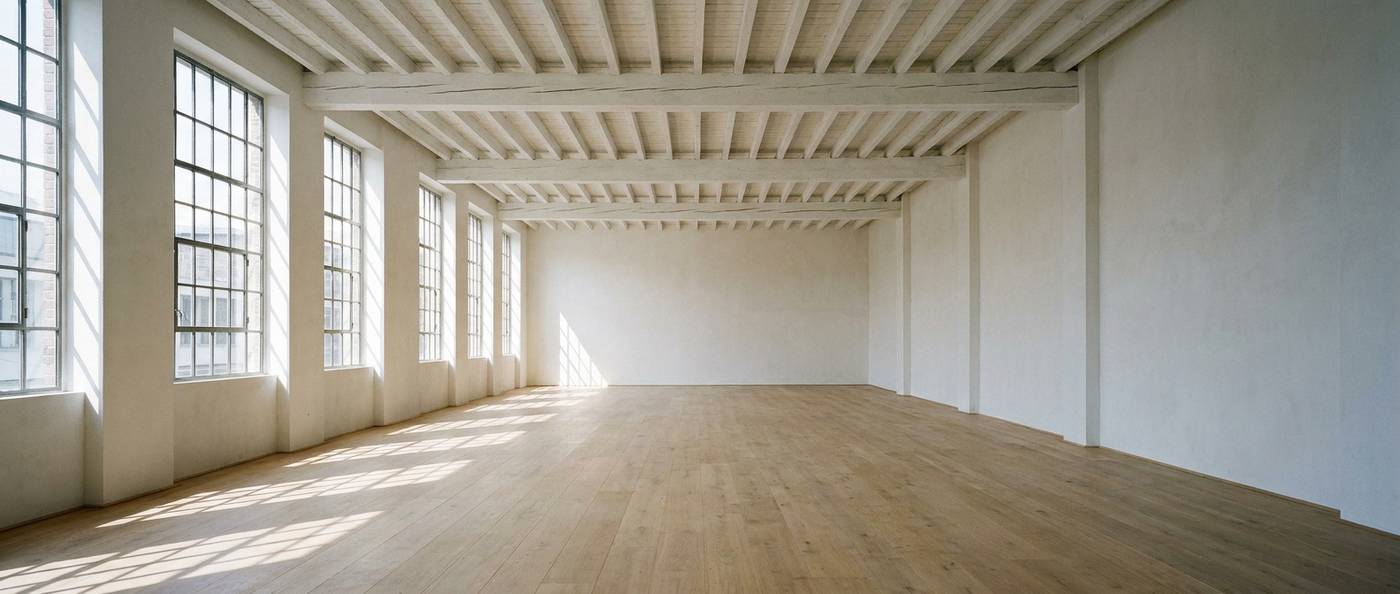 The interior of a large empty community fellowship hall with a wide clear span and exposed steel roof trusses